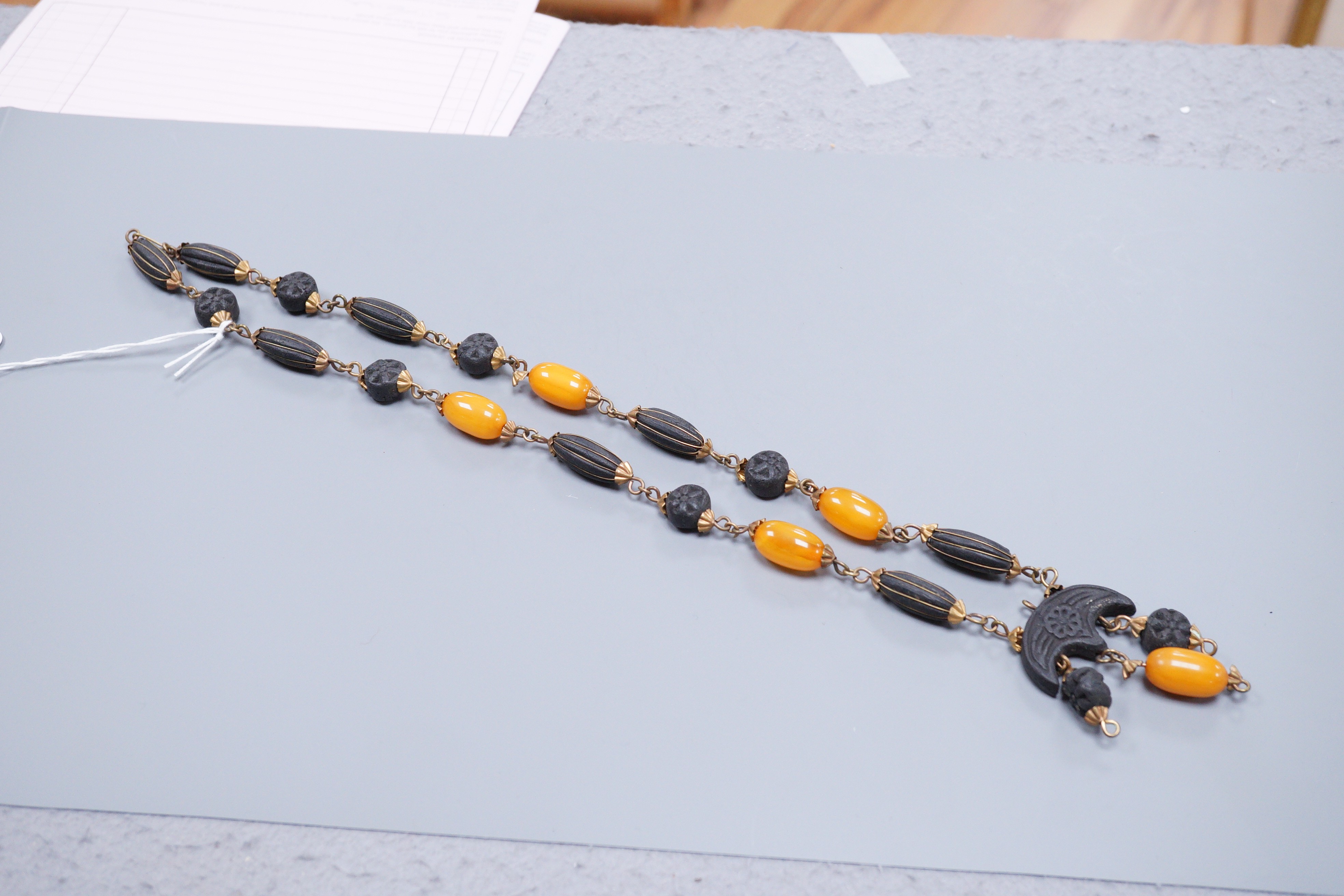 A 1930's gilt brass mounted composition and simulated amber bead necklace, 40cm